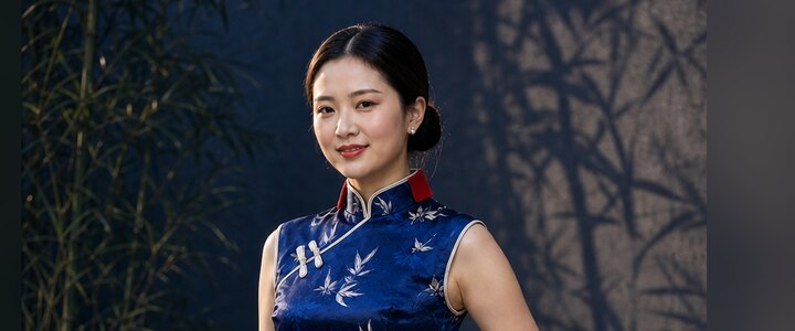 Hanching-Qipao: Modell in indigoblauem Satin-Qipao mit Bambusblattmuster, rotem Stehkragen und handgefertigten Knopfverschlüssen